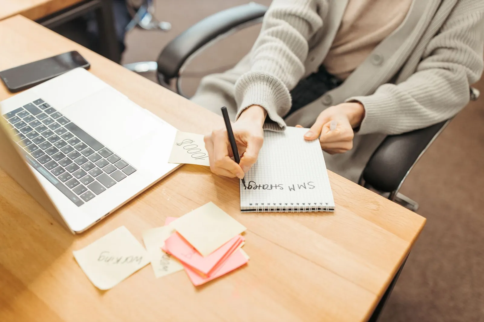 Analyst working at a bright desk with a laptop and handwritten strategy notes